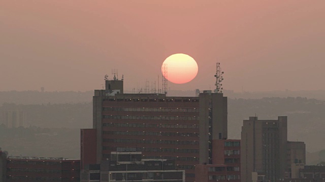 太阳在约翰内斯堡市中心的公寓楼上空盘旋视频素材