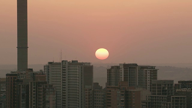 太阳在约翰内斯堡市中心的公寓楼上空盘旋视频素材