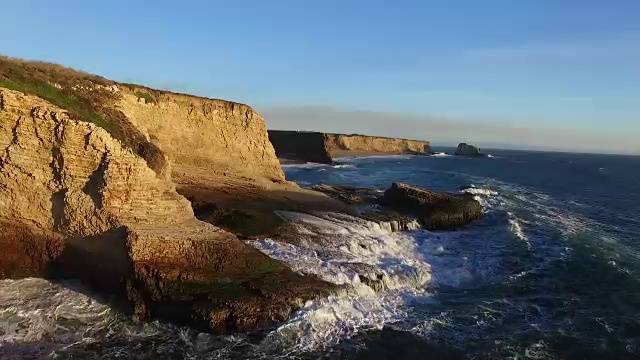 空中低滑翔:海浪撞击悬崖到海滩视频素材