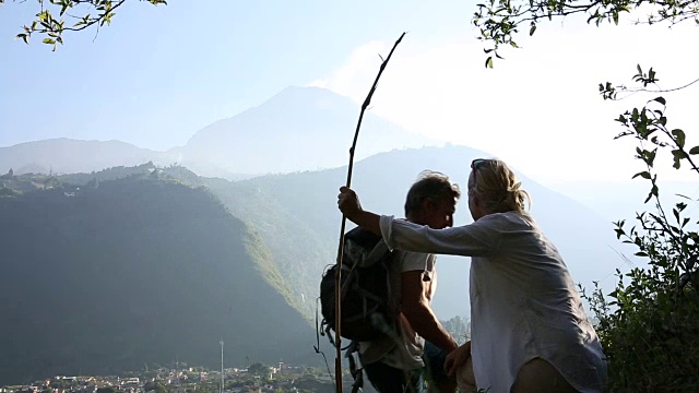 一对夫妇在山路上停下来，后面是火山视频素材