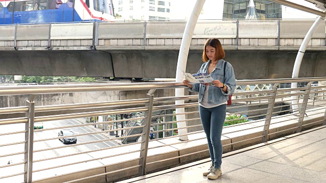 在BTS空中列车上带着旅游地图的年轻女子视频素材