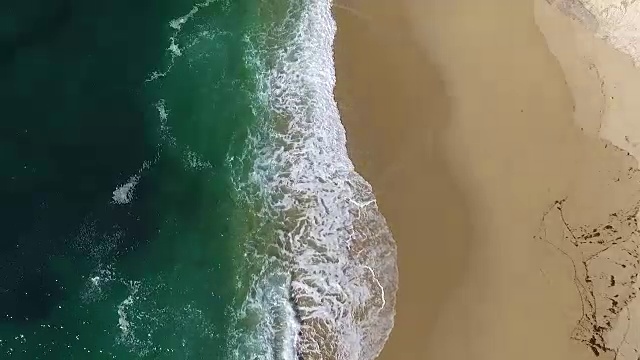 向下空中低空:水浪冲击海滩视频素材