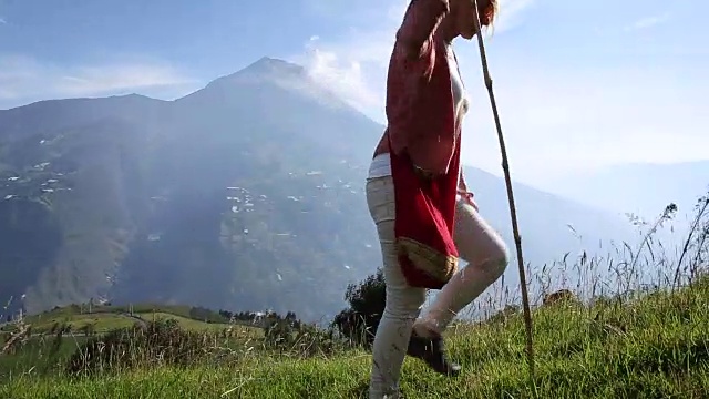 女人走过高山草地下的火山视频素材