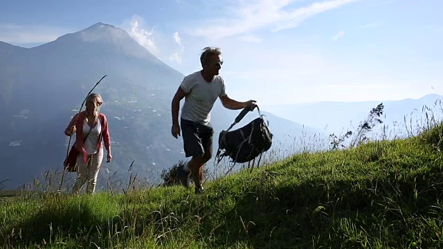 情侣们穿过火山下的高山草地，然后放松视频素材