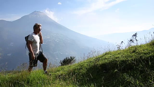 情侣们穿过火山下的高山草地，然后放松视频素材