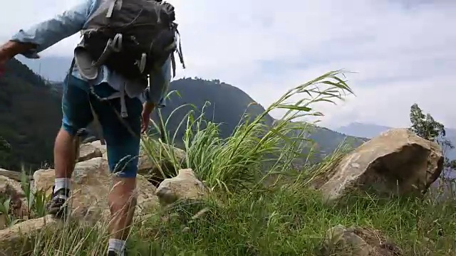 徒步旅行者跳上群山之上的巨石视频素材