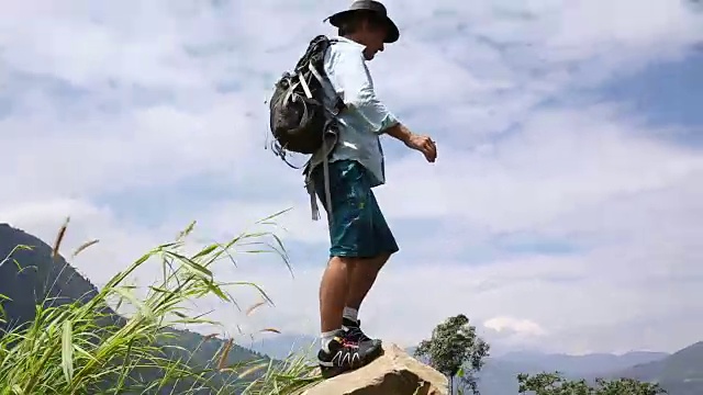 徒步旅行者跳上群山之上的巨石视频素材