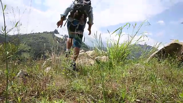 徒步旅行者跳上群山之上的巨石视频素材