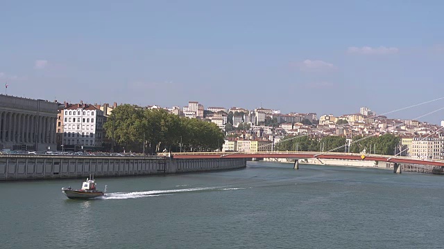 船在河上行驶Saône，后面是Croix Rousse山和La Passerelle du Palais de Justice桥视频素材