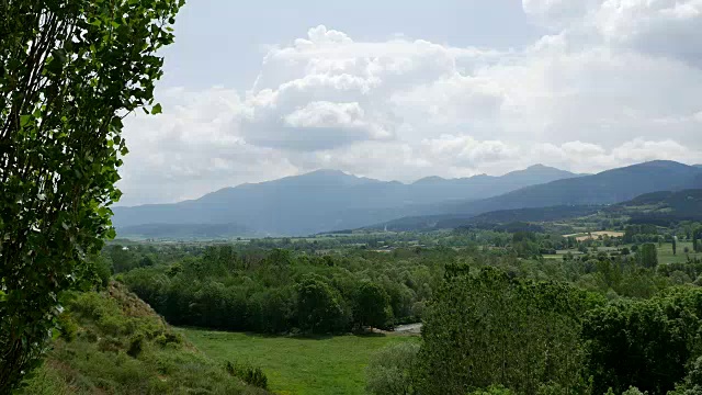 西班牙比利牛斯山的云朵笼罩在树木繁茂的山丘和田野上视频素材