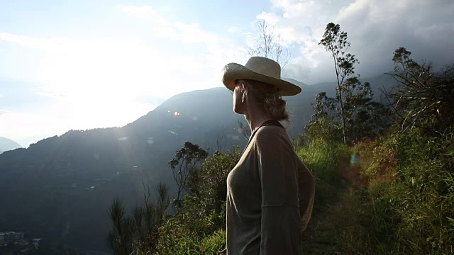 一个女人停在山谷上方的山间小路边视频素材