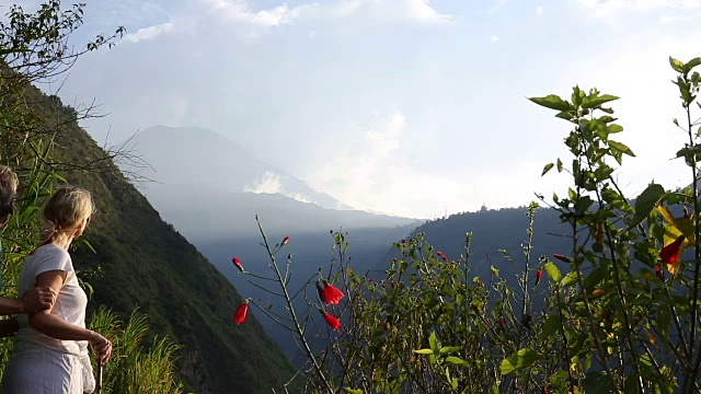 徒步情侣走到山边的小路，上面是火山视频素材