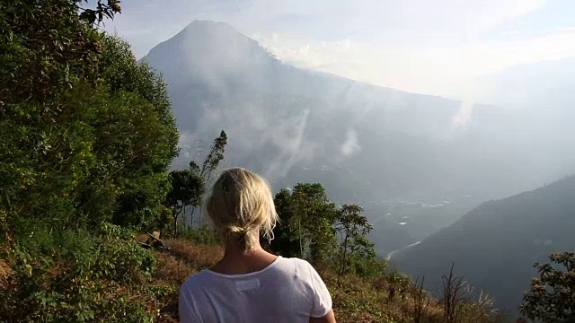 一个女人停在山谷上方的山间小路边视频素材