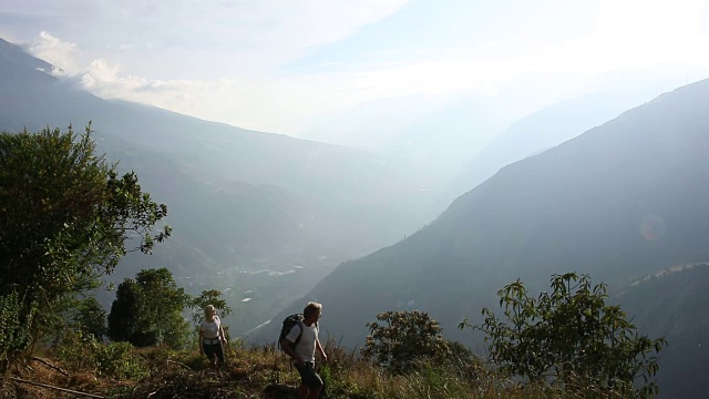 夫妇攀登山径，高于山谷视频素材