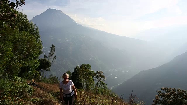 女人爬上山间小路，越过山谷视频素材