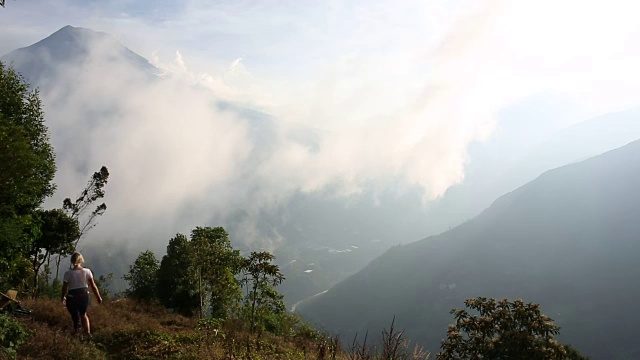 一个女人停在山谷上方的山间小路边视频素材