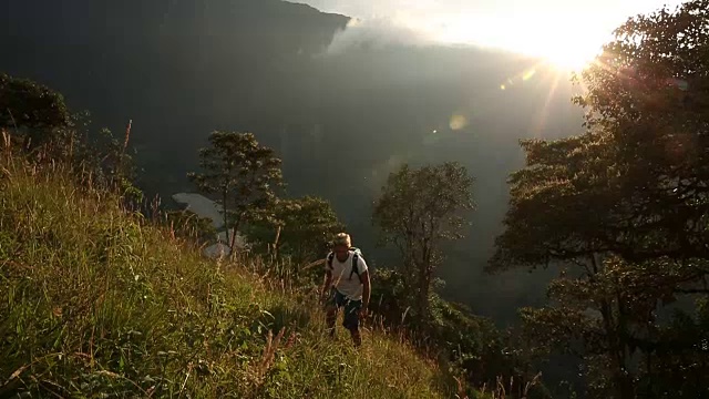 23、男人攀登山坡，日出越过山脊后视频素材