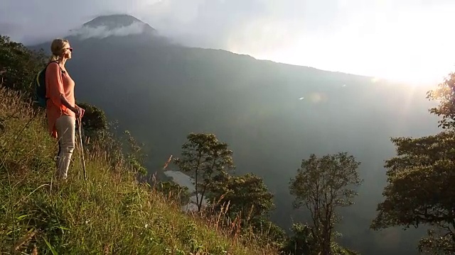 一个女人停在山坡上，望着日出视频素材