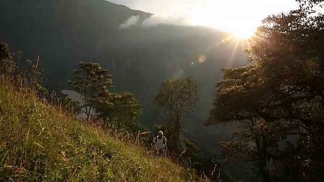 23、男人攀登山坡，日出越过山脊后视频素材