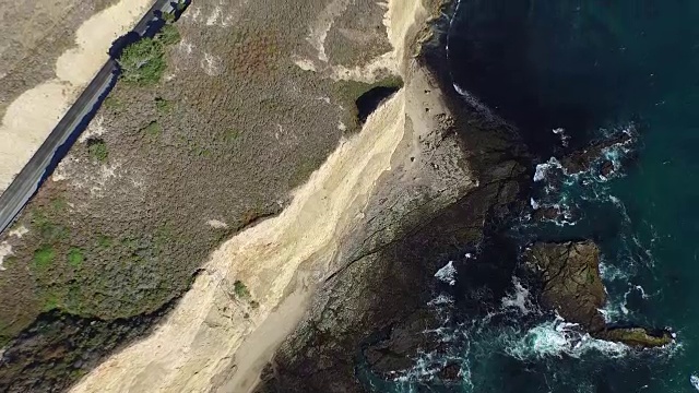 向下的高空倾斜:4K超高清海浪撞击岩石海岸视频素材