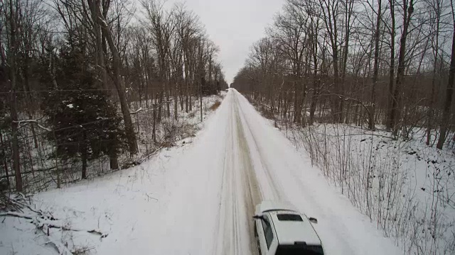 冬季乡村公路上的一辆白色皮卡的航拍视频下载