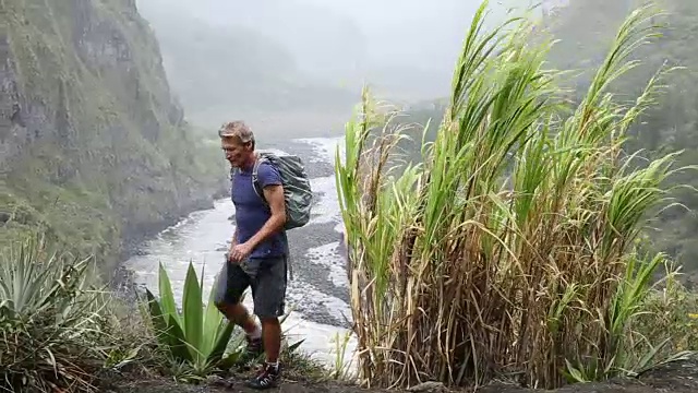 徒步者走上河谷的山顶，向远处望去视频素材