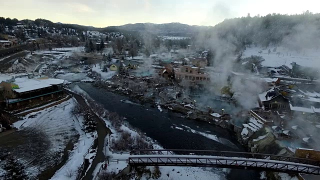 鸟瞰图冬季仙境Pagosa Springs科罗拉多桥在圣胡安河温泉蒸汽提升冬季雪覆盖的落基山脉与漂亮的运动锅视频素材