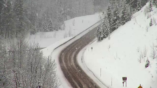 长焦拍摄的铺路公路在冬天期间，大雪暴风雪。视频素材