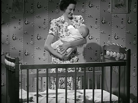 1948年，一名妇女把婴儿塞进婴儿床/工业视频素材