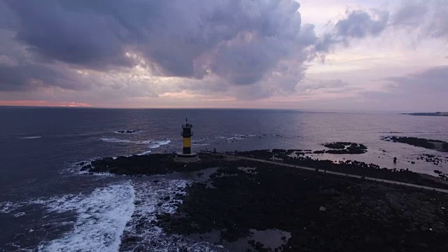 碧阳都岛(旅游目的地)日落时的海景，有灯塔和水上地平线视频素材