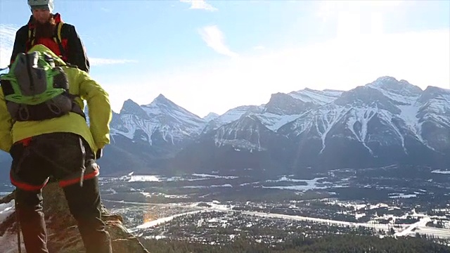 两个年轻的登山家沿着山脊行走视频素材