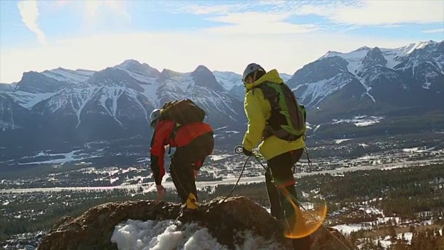 两个年轻的登山家沿着山脊行走视频素材