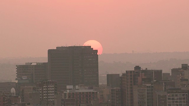 太阳在约翰内斯堡市中心的建筑物上空盘旋视频素材