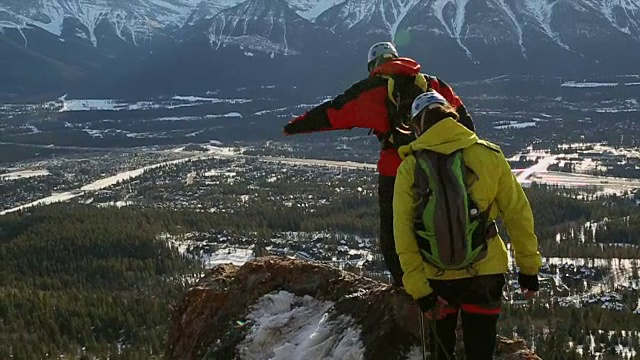 两个年轻的登山家沿着山脊行走视频素材