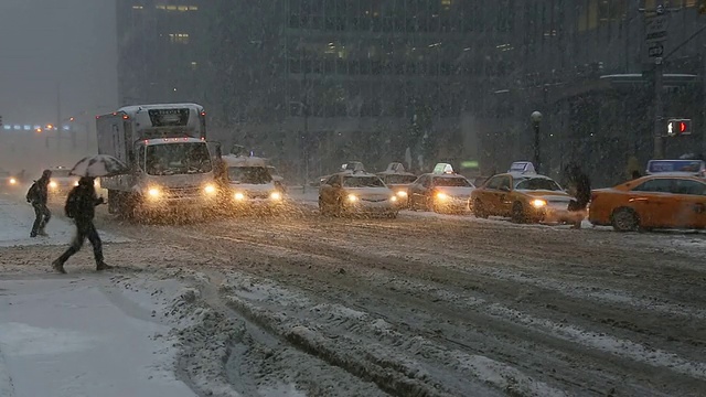 图女士拍摄的是美国纽约冬季暴风雪中第六大道的交通和通勤者视频素材