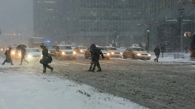 图女士拍摄的是美国纽约冬季暴风雪中第六大道的交通和通勤者视频素材