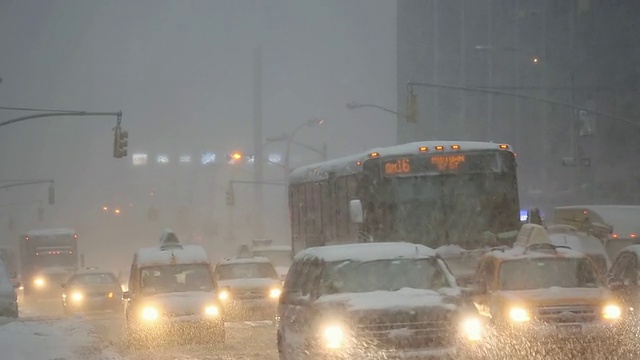 图女士拍摄的是美国纽约冬季暴风雪中第六大道的交通和通勤者视频素材