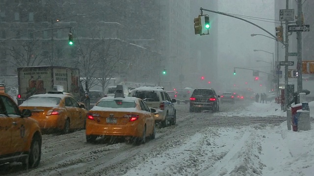 图女士拍摄的是美国纽约早晨冬季暴风雪期间第六大道的交通状况视频素材