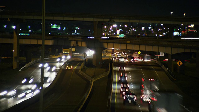 夜间时间流逝交通竞赛在两个方向下的多车道州际公路和跨桥梁。视频素材