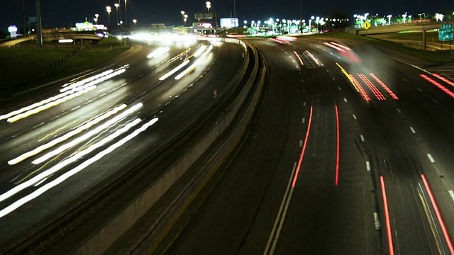 夜幕降临，时间流逝，州际公路拐弯处交通模糊视频素材