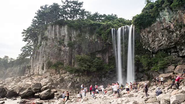 人们欣赏钟邦瀑布(瀑布直接流入大海)视频素材