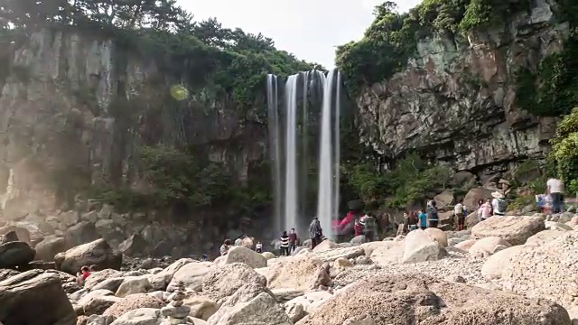 人们欣赏钟邦瀑布(瀑布直接流入大海)视频素材