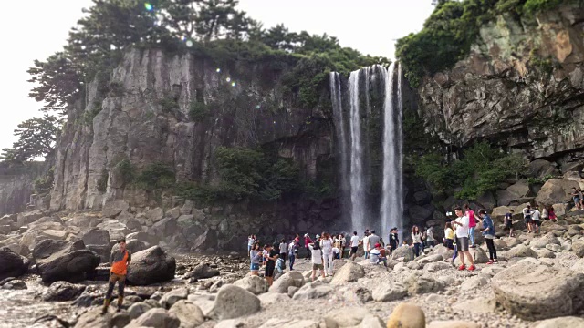 人们欣赏钟邦瀑布(瀑布直接流入大海)视频素材