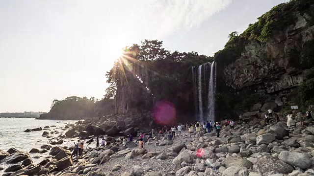 人们欣赏钟邦瀑布(瀑布直接流入大海)视频素材