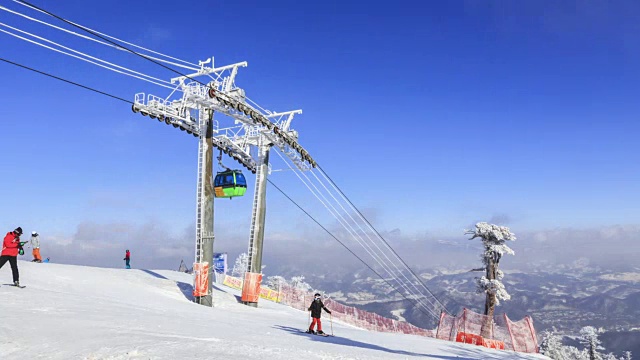 在平昌郡滑雪场，人们在雪地上和头顶缆车上骑滑雪板和滑雪视频素材