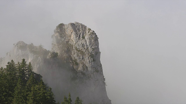 云层覆盖着岩石山脉和树木视频素材