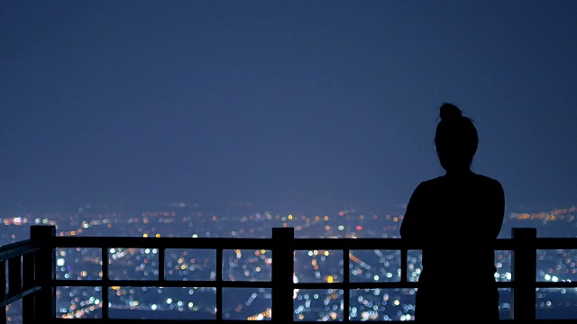 一对年轻夫妇在夜晚的城市背景中寻找明星，4k(超高清)视频素材