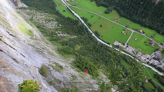 翼装飞行员从悬崖上跳下，在山谷上空翱翔视频素材