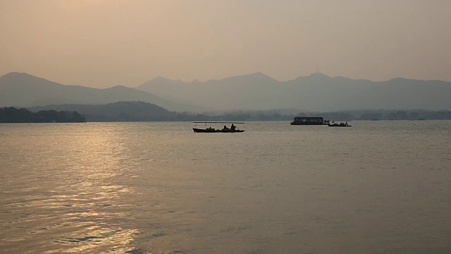 黄昏时分，中国杭州，游船在西湖上漂浮视频素材