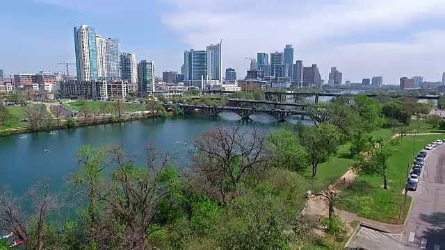 鸟瞰图奥斯汀德克萨斯天际线科罗拉多河有趣的泉水活动低附近的树与慢跑的徒步和自行车道视频素材